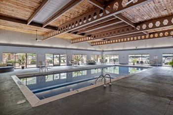 a large indoor swimming pool with a wooden ceiling